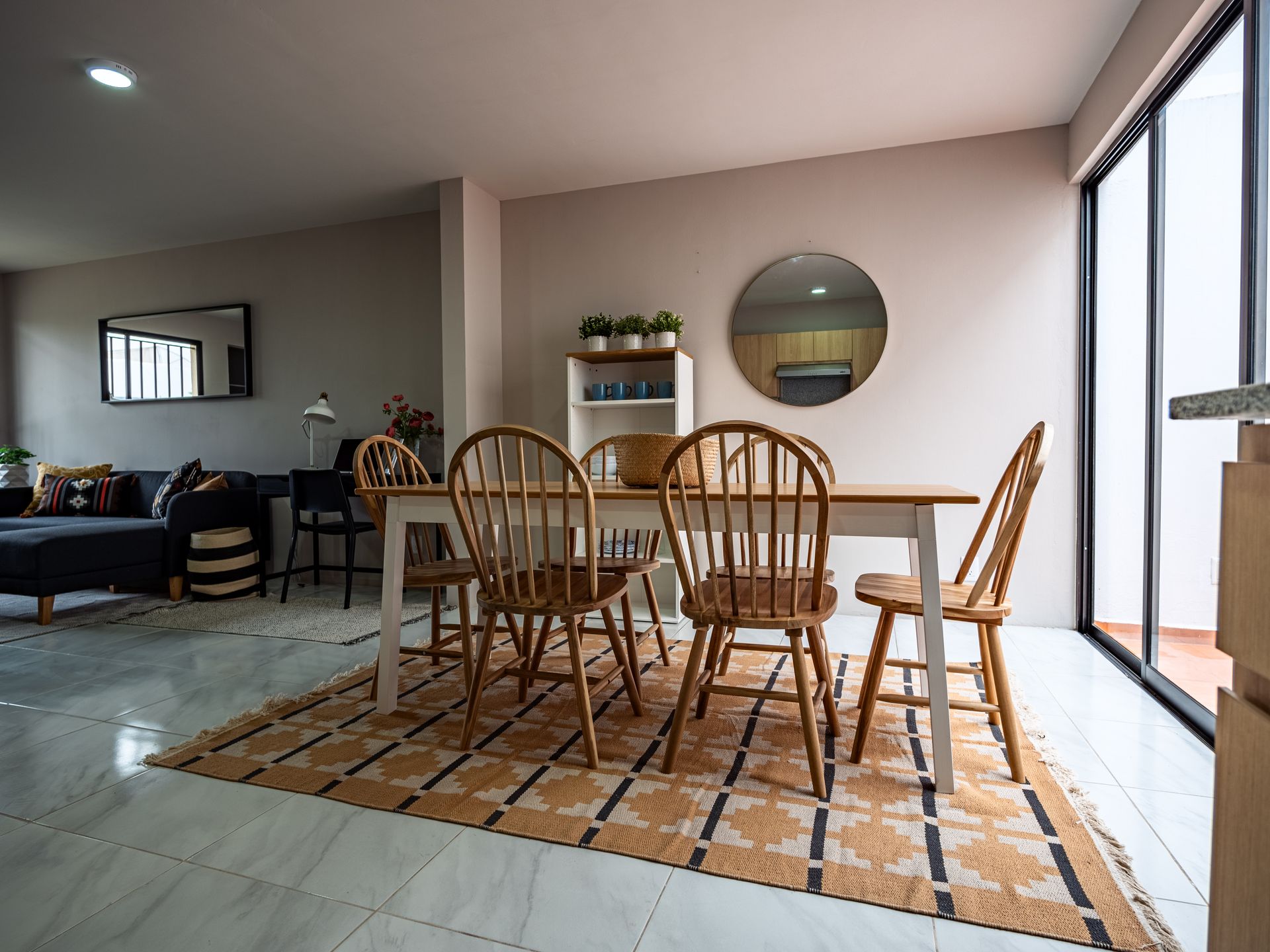 Un comedor con una mesa y sillas y una alfombra.