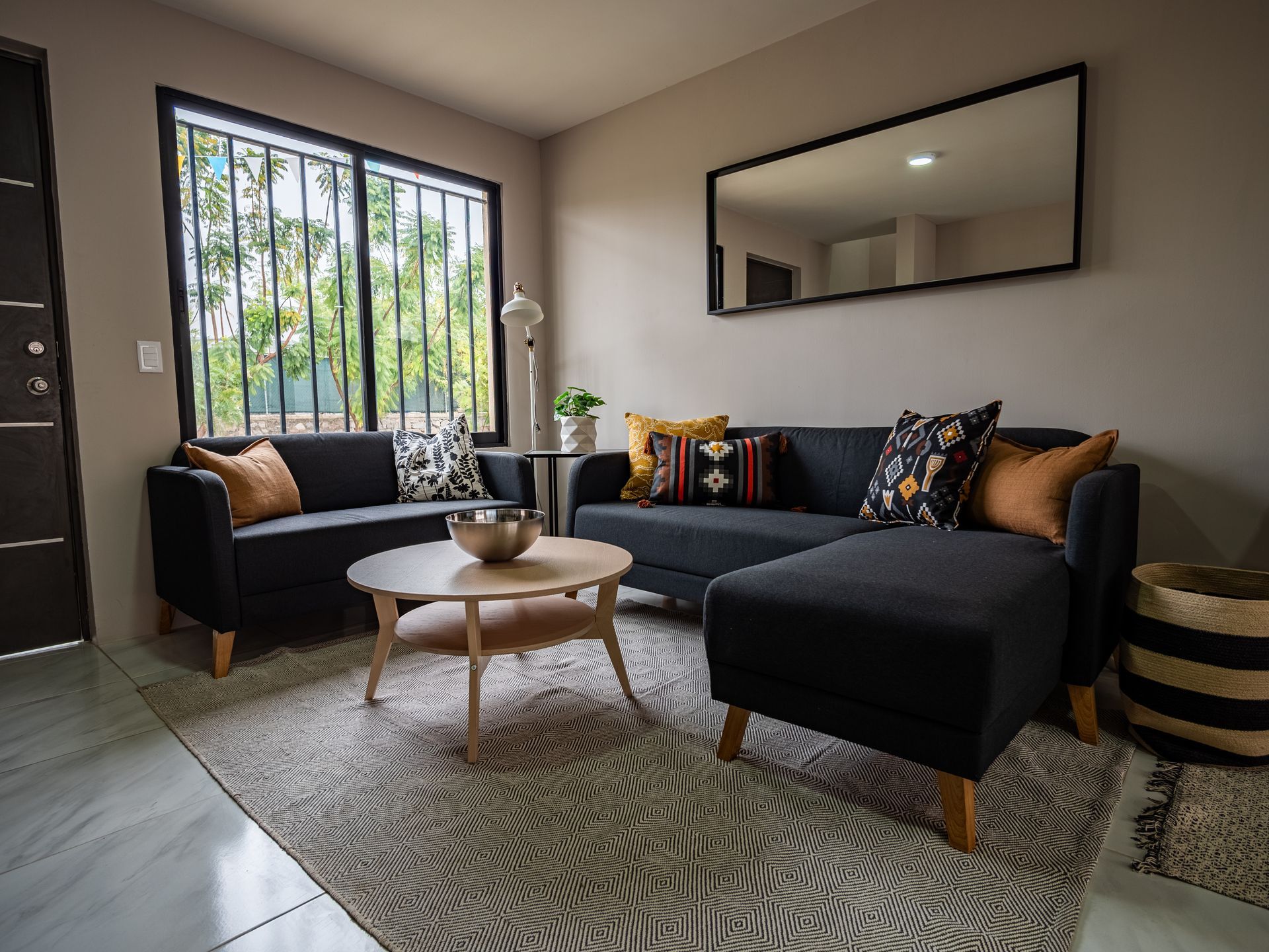 Una sala de estar con dos sofás, una mesa de café y un espejo.