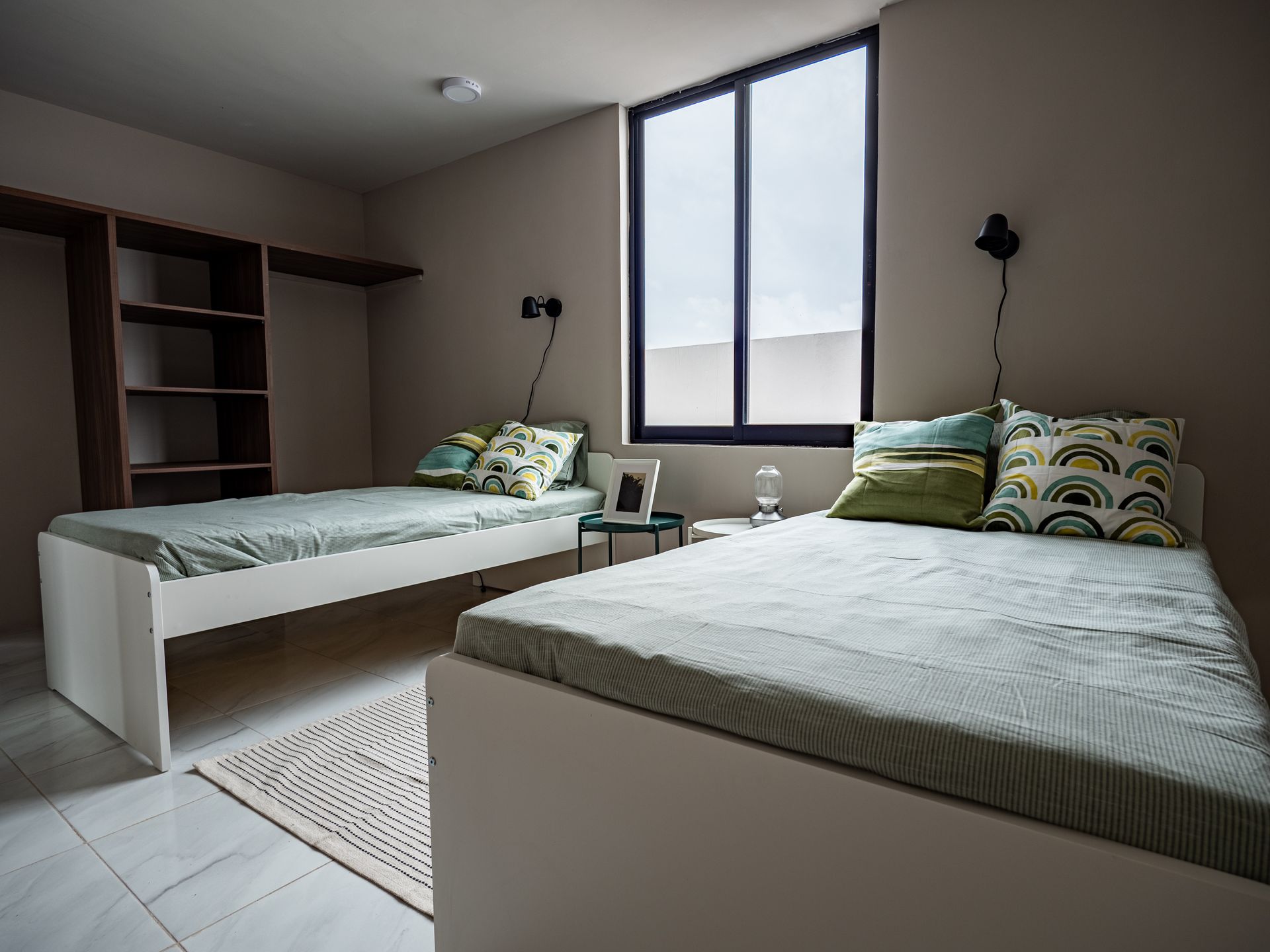 Un dormitorio con dos camas y una ventana.