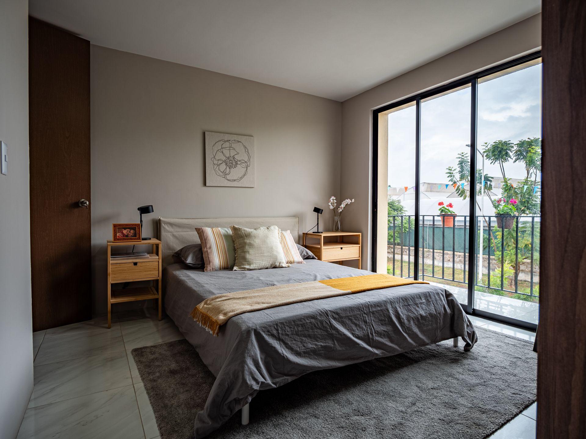 Un dormitorio con una cama grande y puertas corredizas de vidrio que conducen a un balcón.