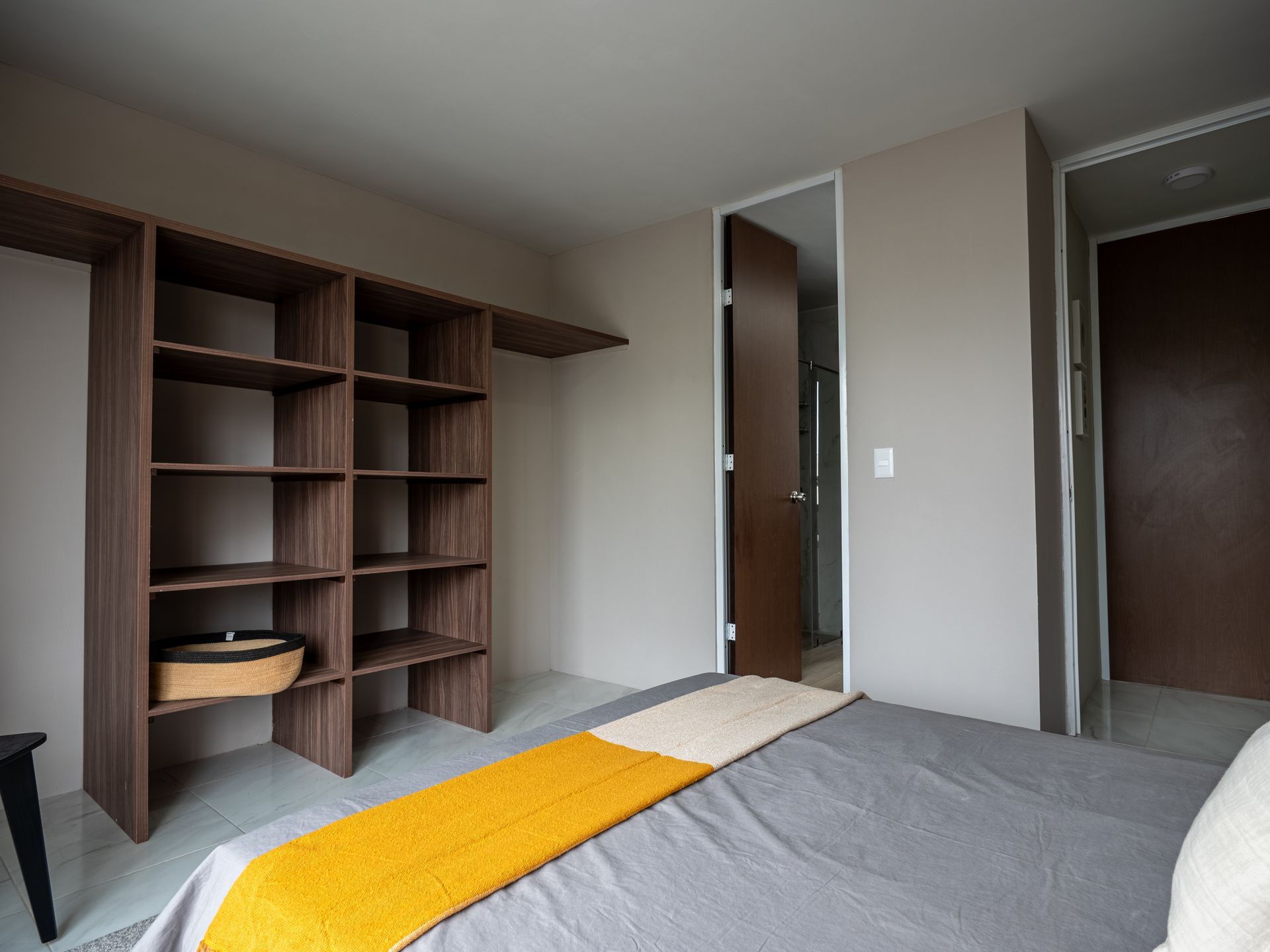 Un dormitorio con una cama, estantes y una puerta.