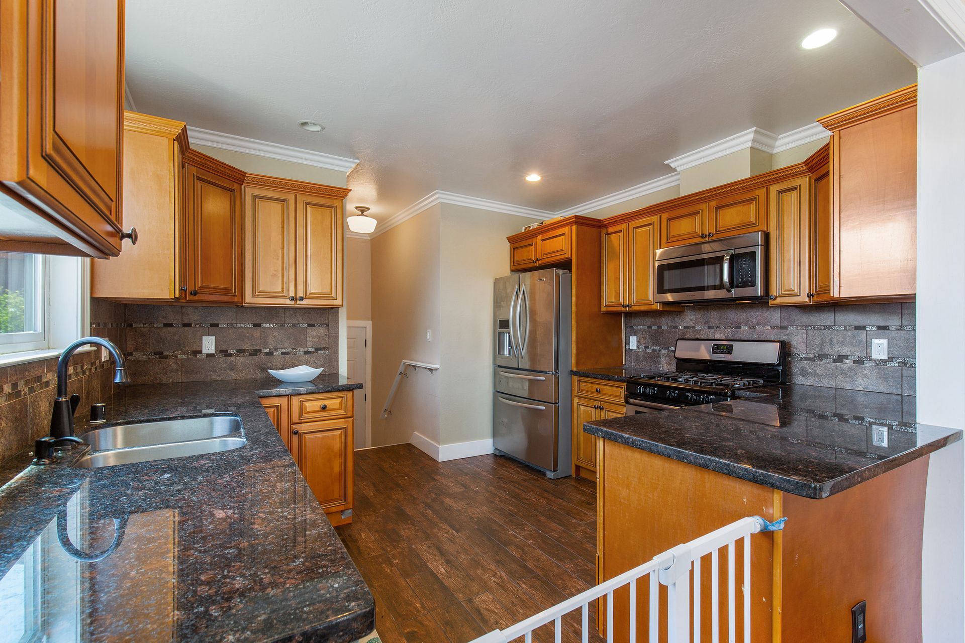 A kitchen with granite counter tops and wooden cabinets