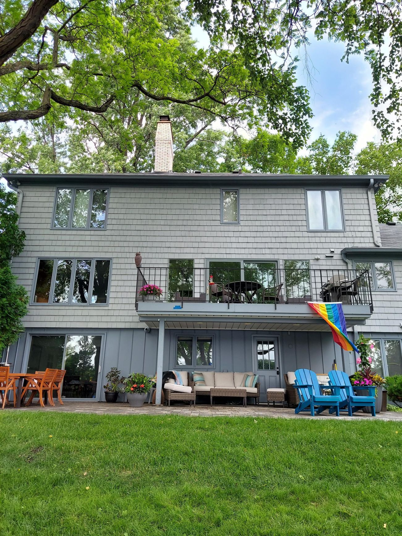 The back of a house with a rainbow flag on the patio.