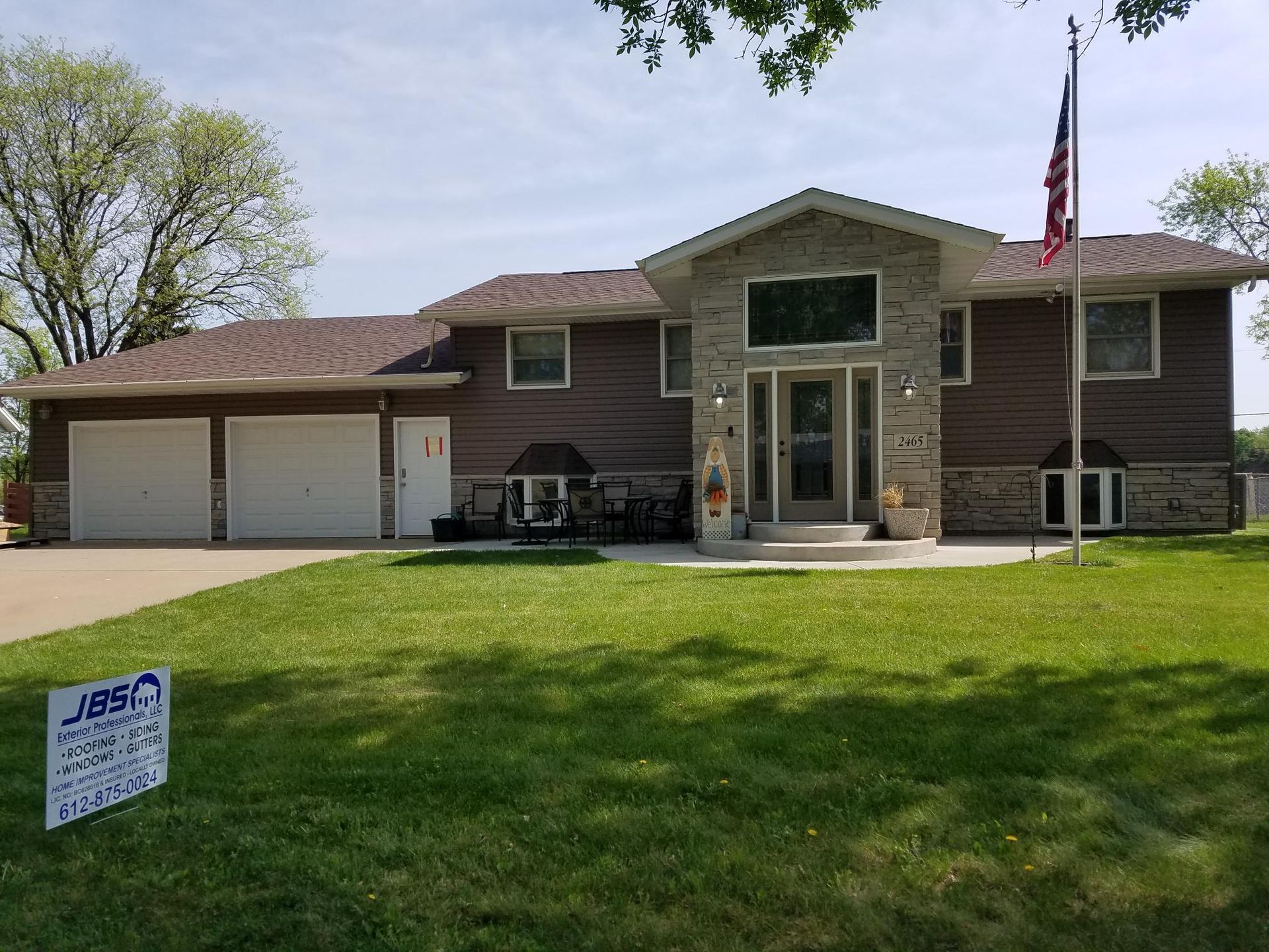 A large house with a sign in front of it.