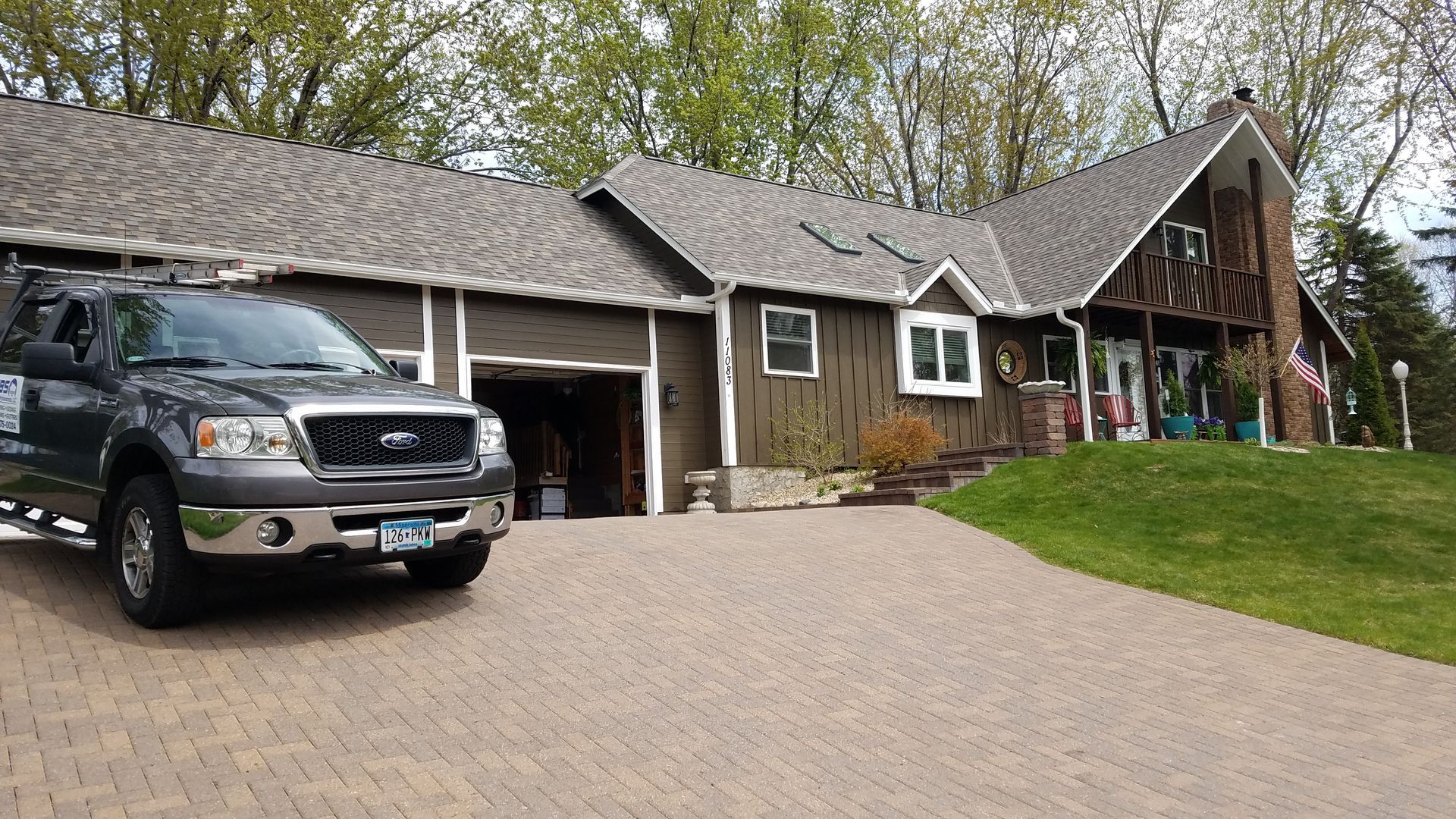 A truck is parked in front of a large house.