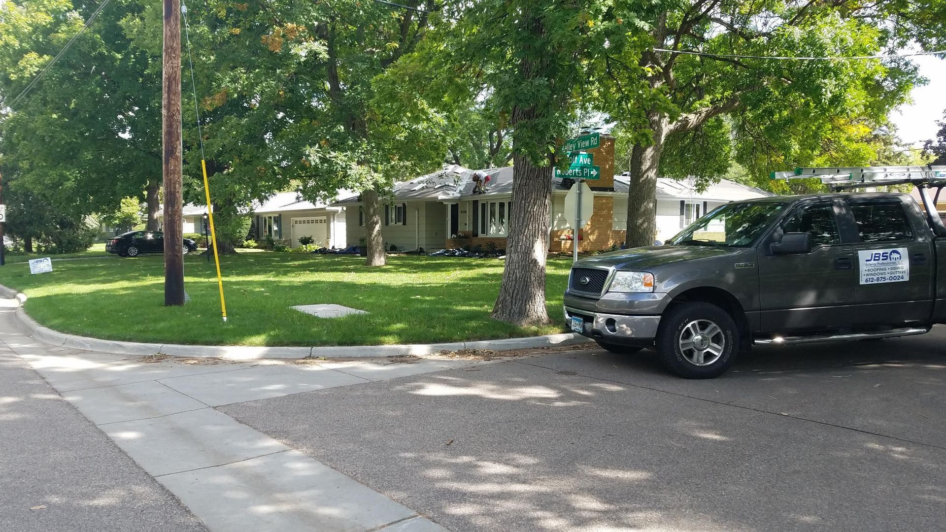 A truck is parked on the side of the road in front of a house.