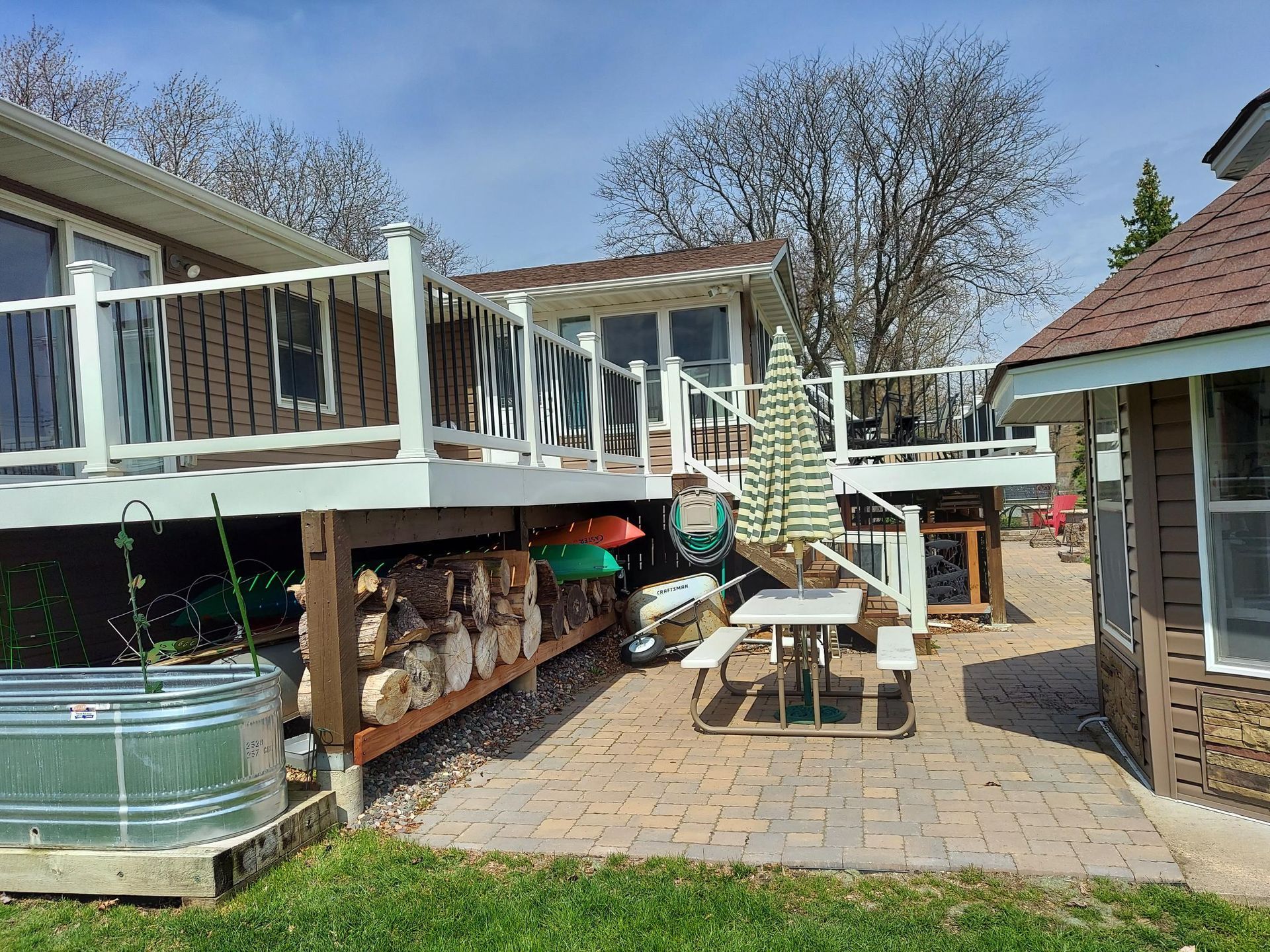 A house with a deck and a picnic table in the backyard.