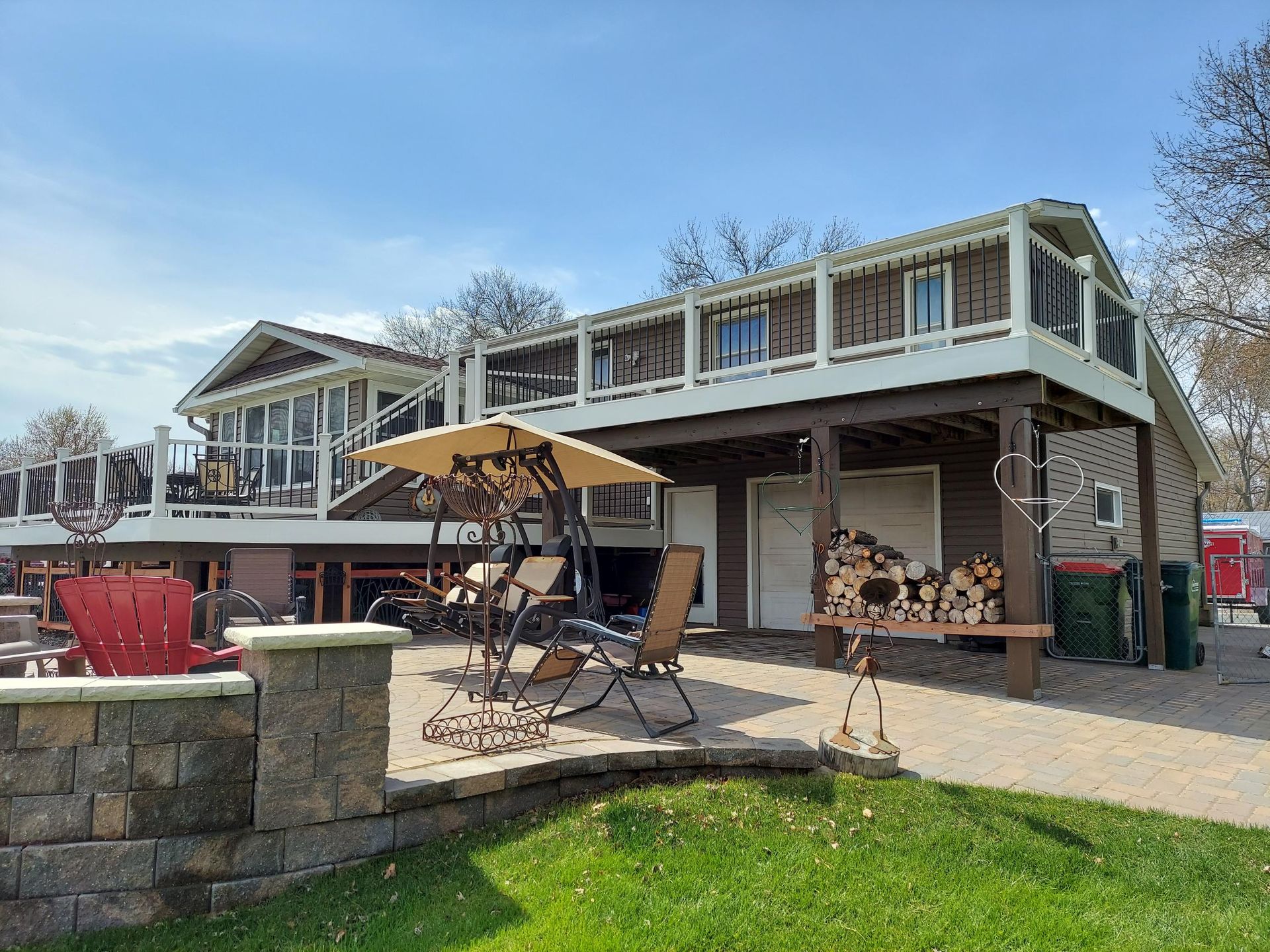 A large house with a large deck and a fire pit in front of it.