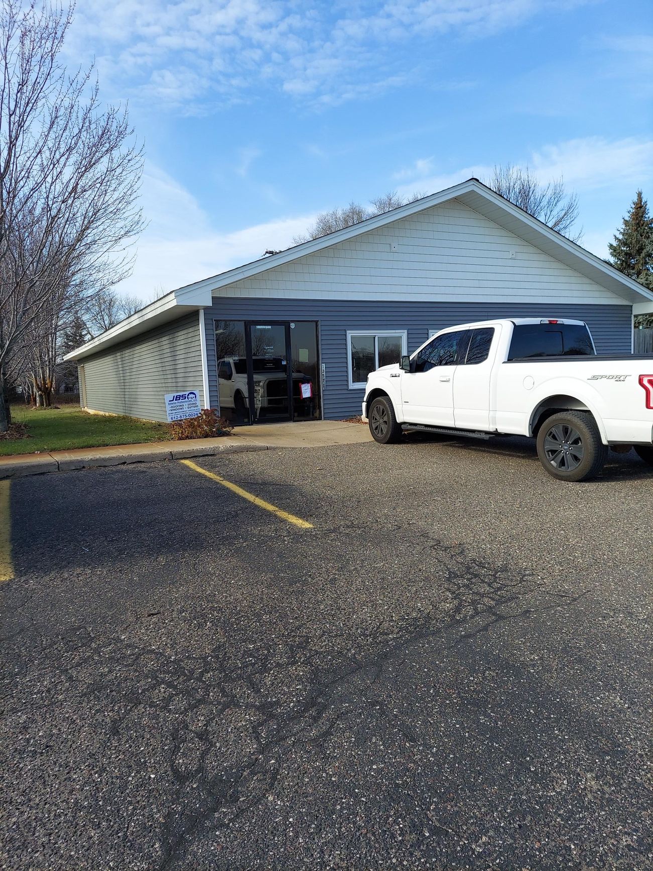 A white truck is parked in front of a building.