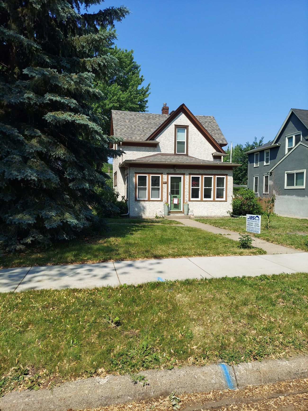 A house with a lot of grass and trees in front of it