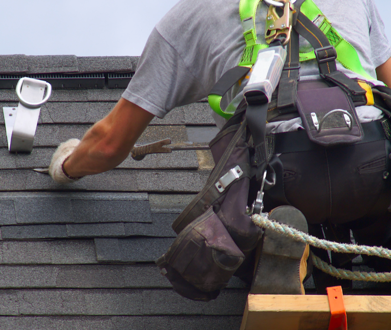 A man is working on the roof of a building