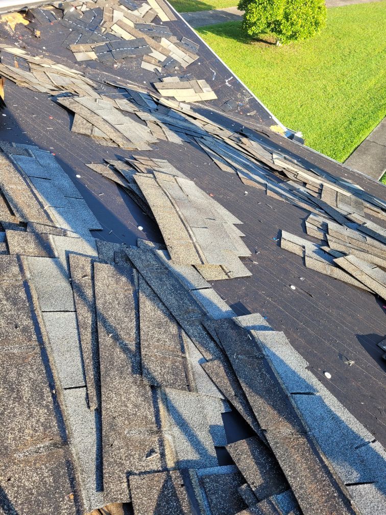 A roof with a lot of shingles on it is being repaired.