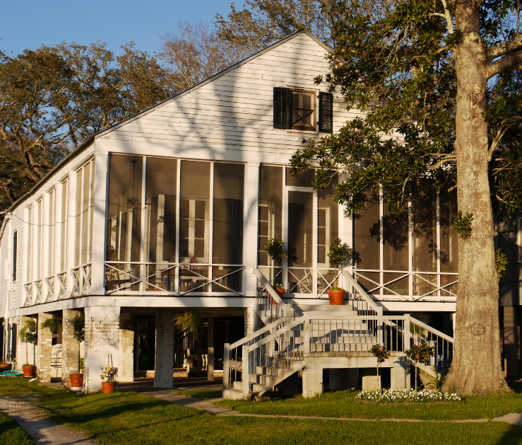 A white house with a screened in porch and stairs