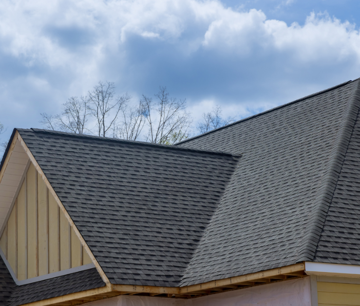 A house with a gray roof and a blue sky in the background.
