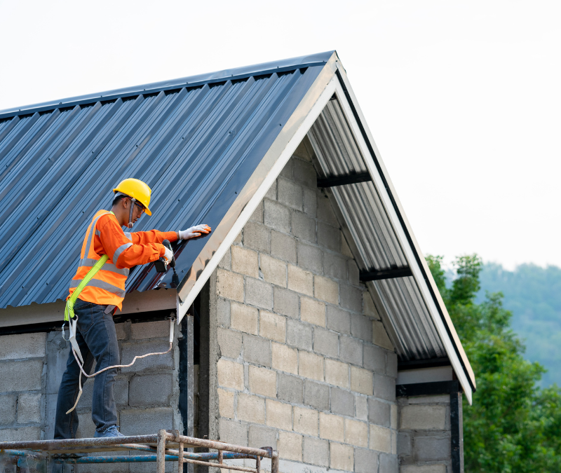 A man is working on the roof of a house.