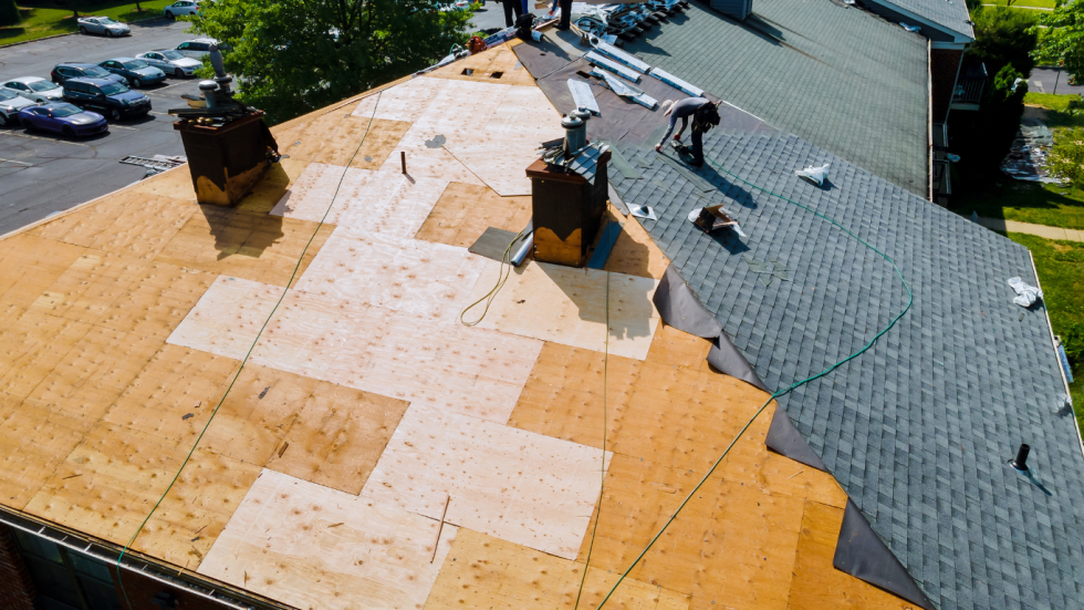 An aerial view of a roof being repaired with plywood.
