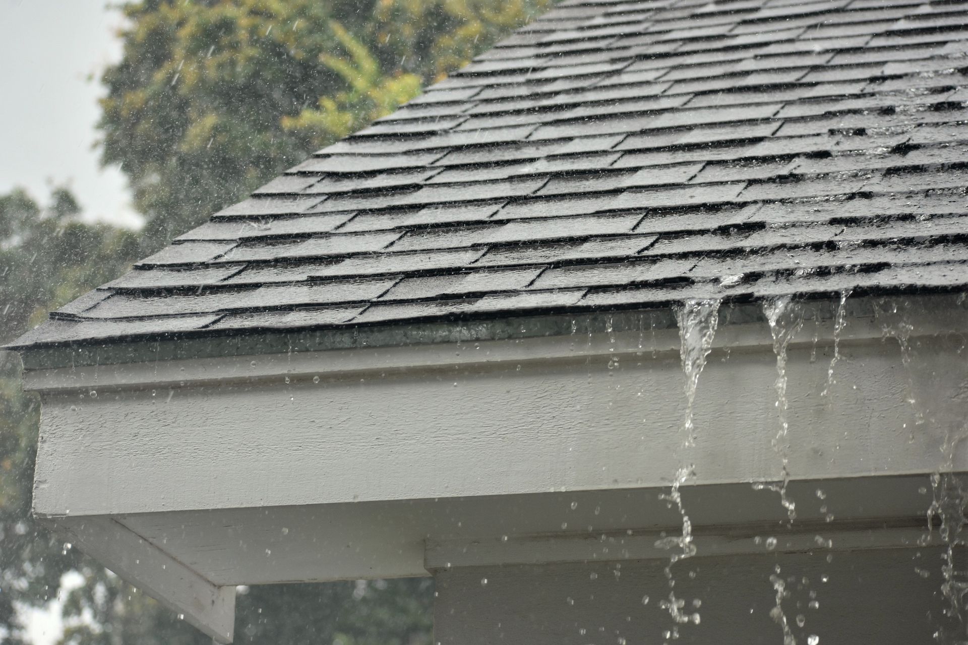 Rain is falling from the roof of a house.