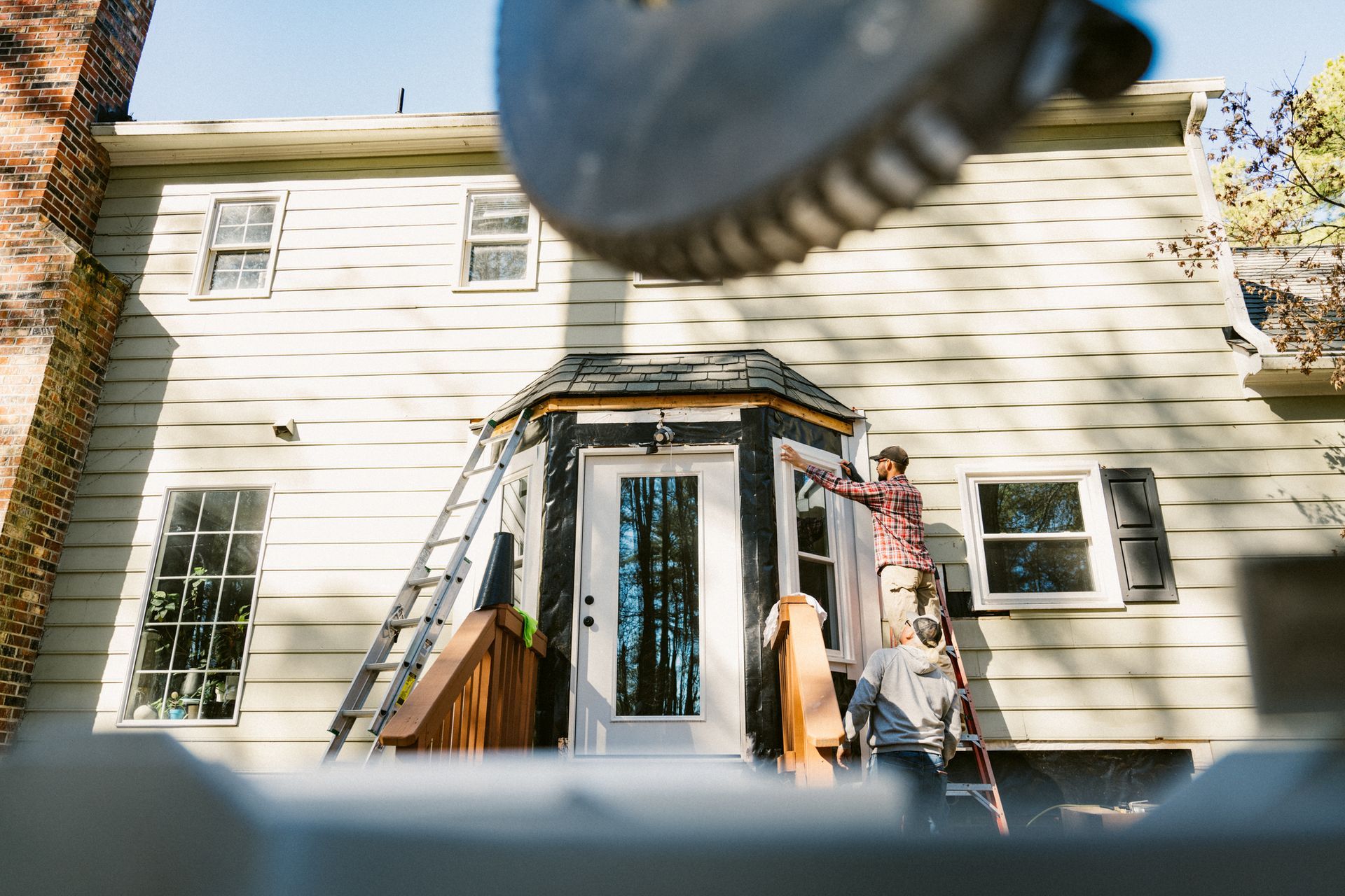 Residential siding installation done by a contractor in a colonial style house.