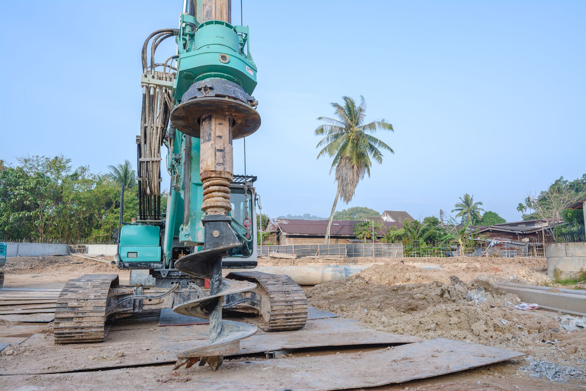 Heavy-duty drilling rig with auger on construction site for foundation work.