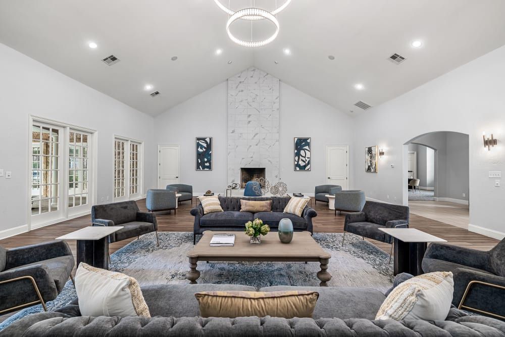 Apartment clubhouse is filled with furniture and a fireplace at Marquis at Silver Oaks in Grapevine, TX.