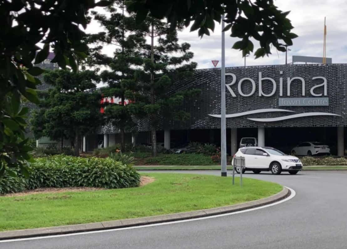 A White Car is Parked in Front of a Building That Says Robina — Trusted Energy Solutions In Robina, QLD