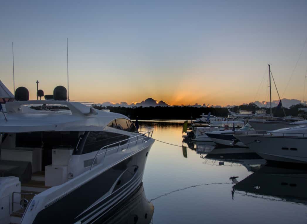A Group of Boats Are Docked in a Marina at Sunset — Trusted Energy Solutions In Sanctuary Cove, QLD