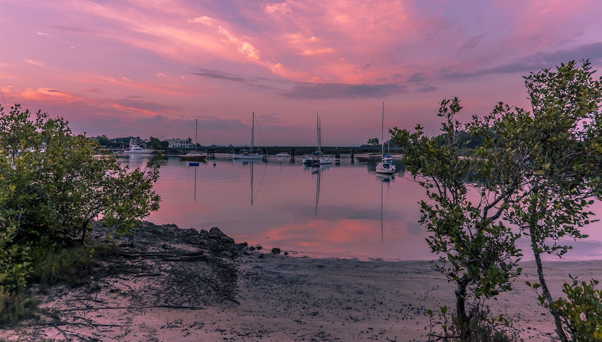A sunset over a body of water with boats in it — Trusted Energy Solutions In Coomera Waters, QLD