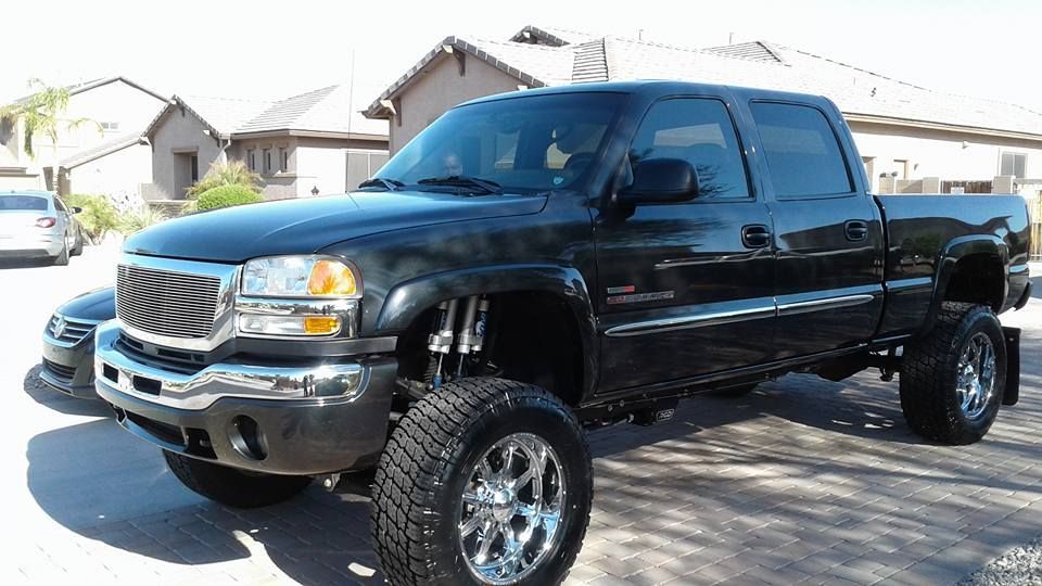 A black pickup truck is parked in front of a house.