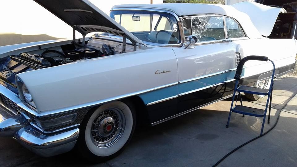 A white and blue car with the hood open