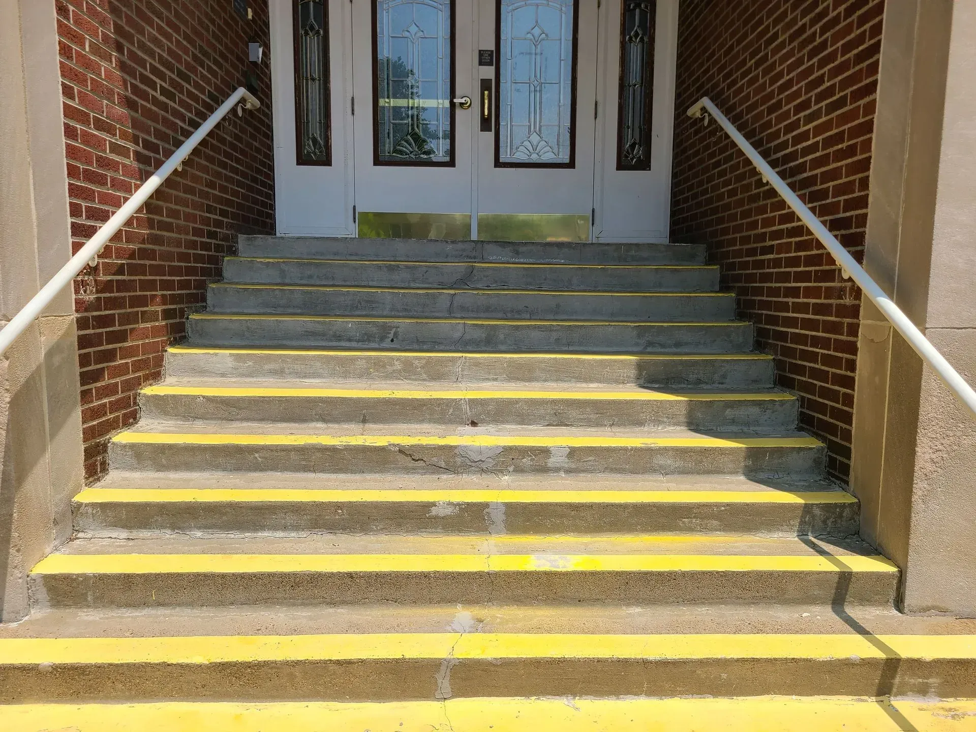 A set of stairs leading up to a brick building with yellow steps.