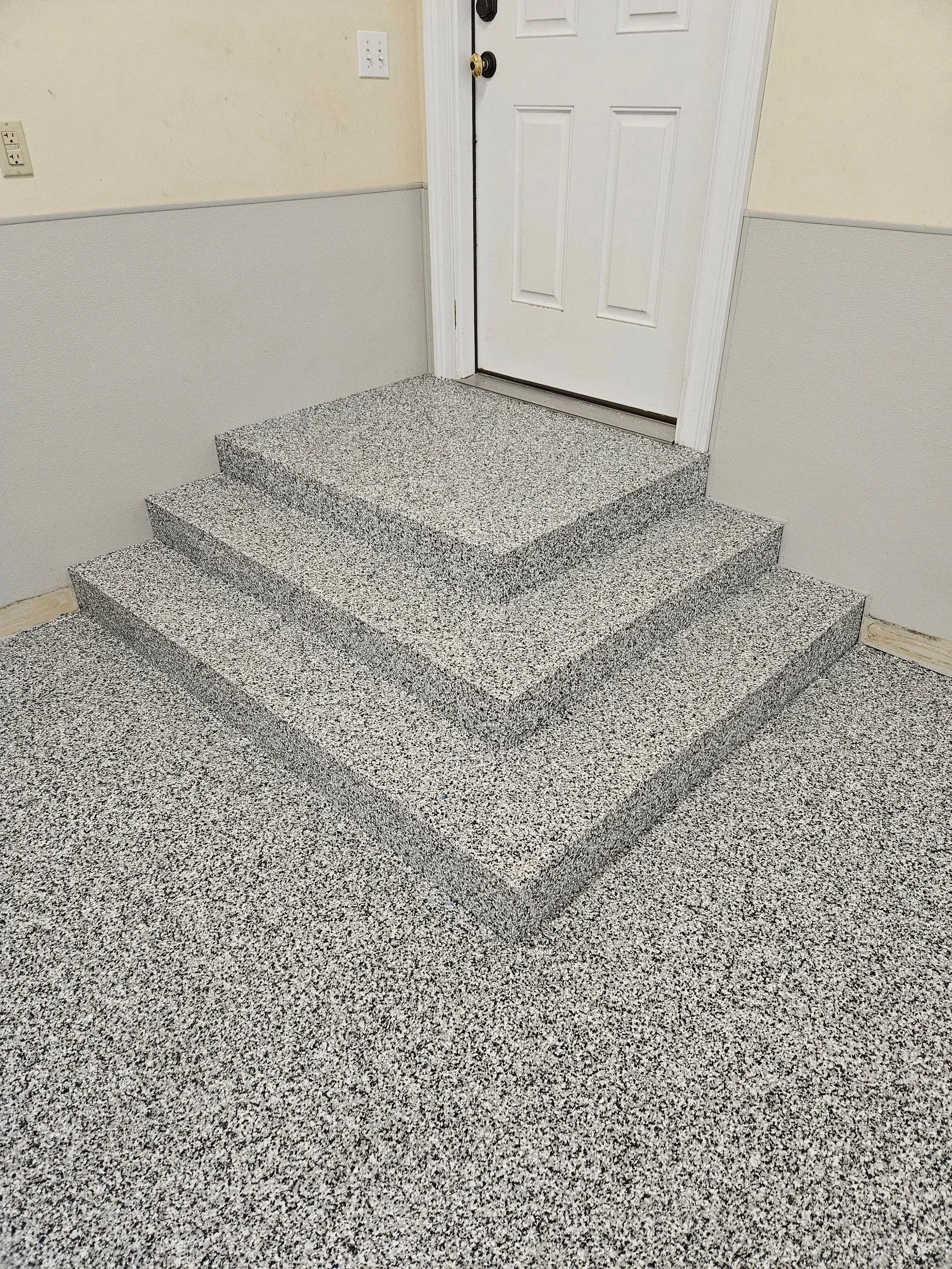 A set of stairs leading up to a door in a garage.