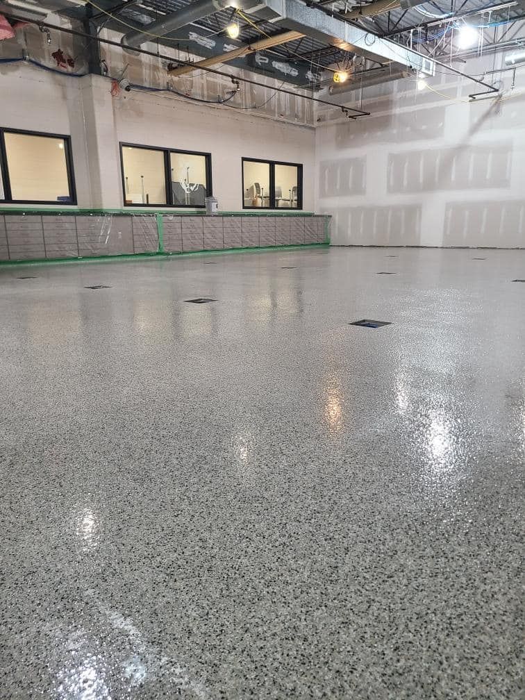 A large empty room with a shiny floor and a lot of windows.