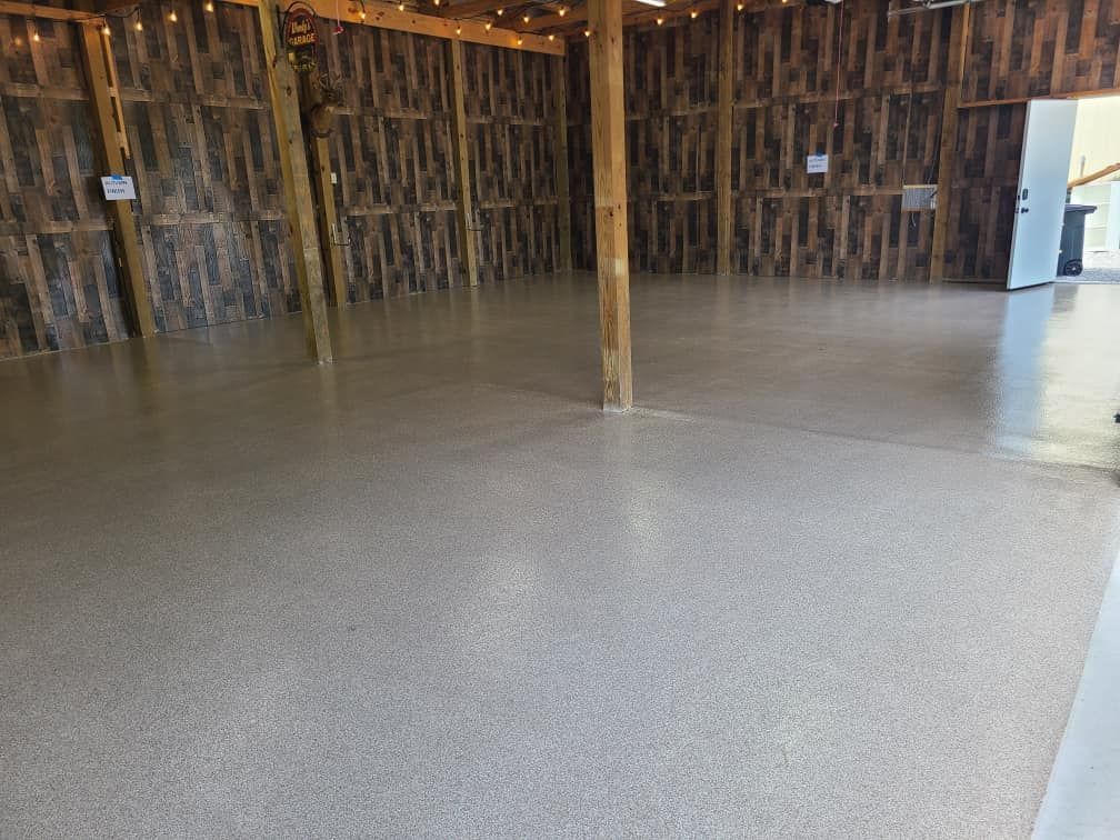 A large empty room with a concrete floor and wooden walls.