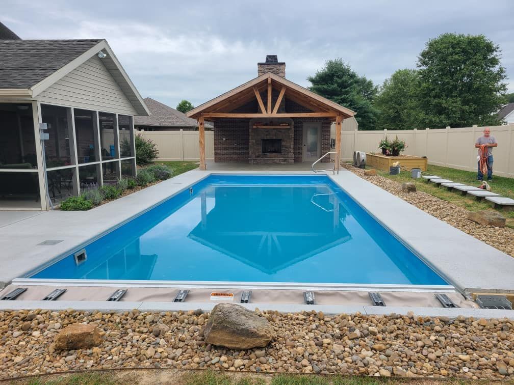 A large swimming pool in the backyard of a house with a screened in porch.