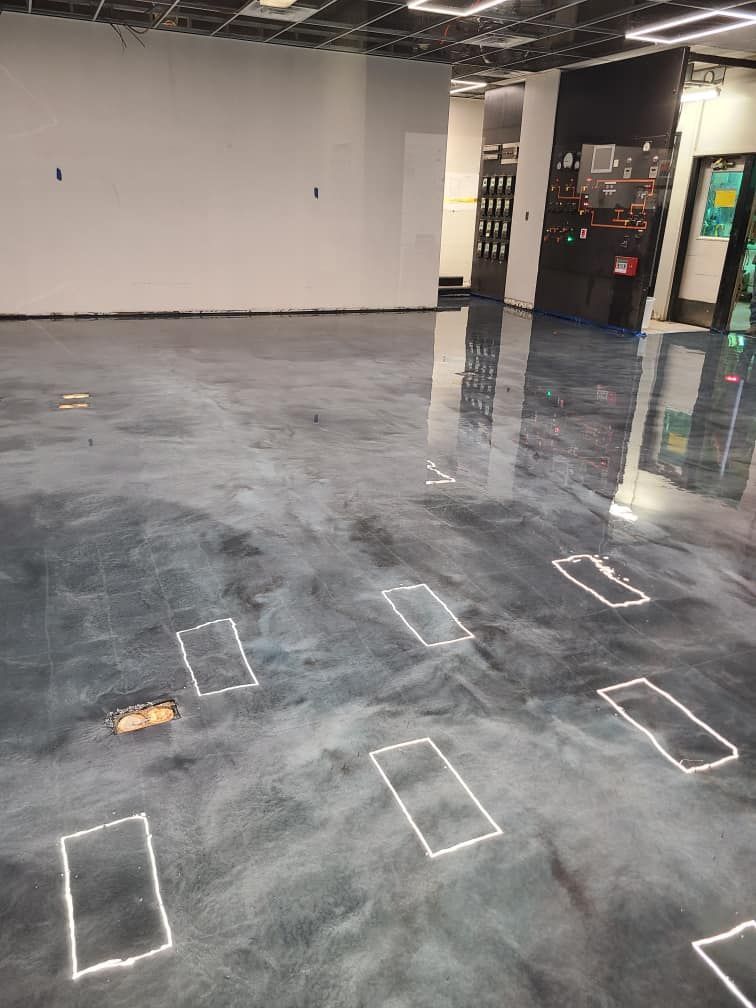 A room with a concrete floor and white squares on it.