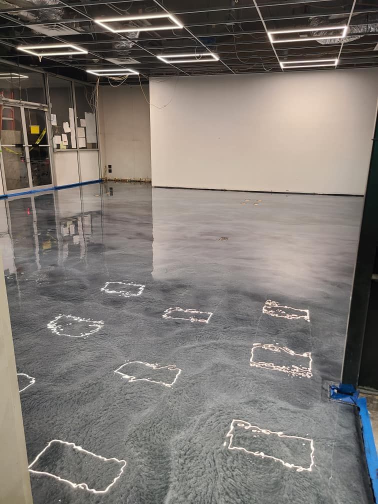 A large room with a concrete floor and a white wall.