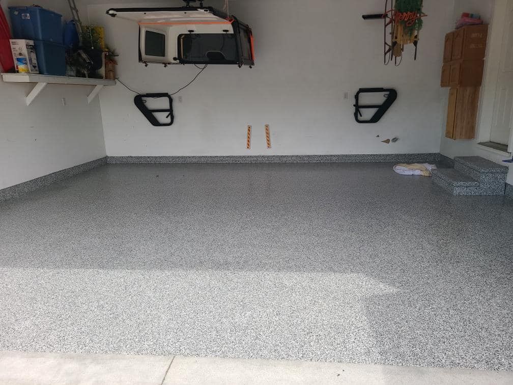 A garage with a gray floor and white walls