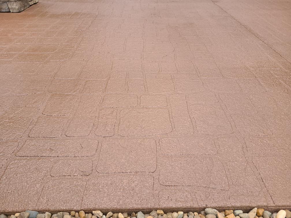 A close up of a brick driveway with rocks on the ground.