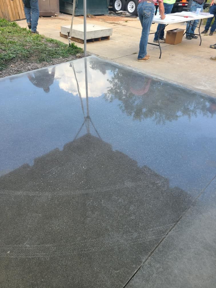 A group of people are standing around a table in a parking lot