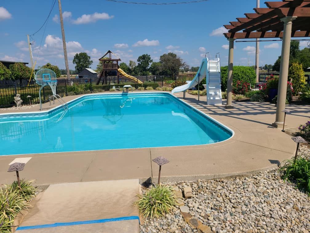 A large swimming pool with a slide in the backyard