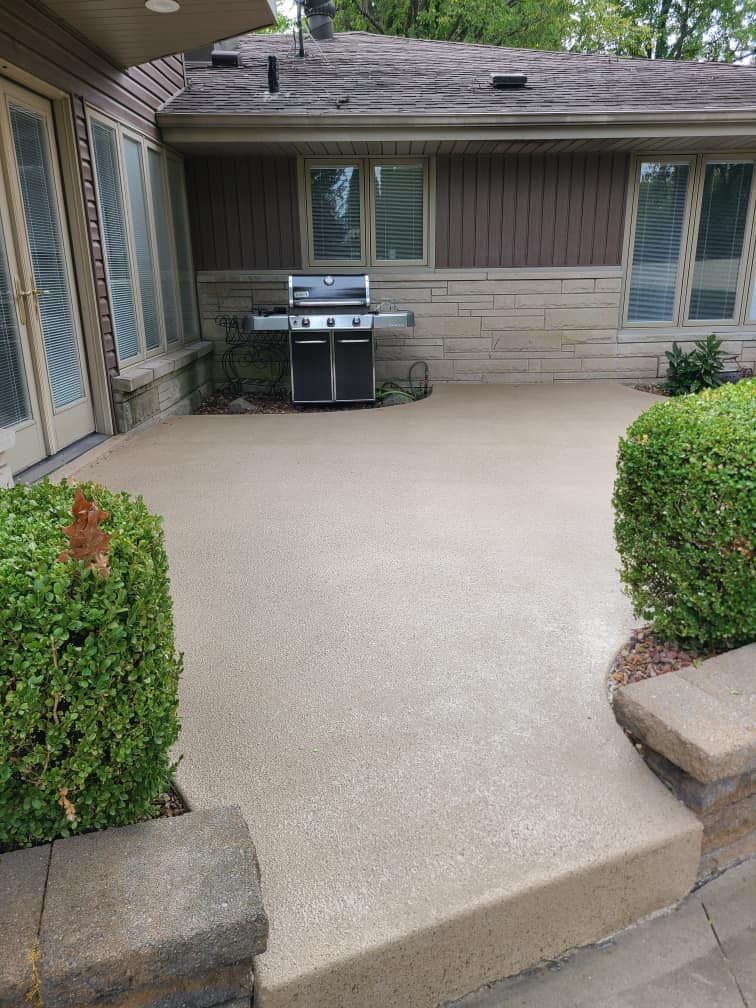 A patio with a grill and a house in the background.