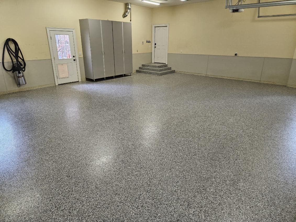 A garage with a gray floor and a white door.