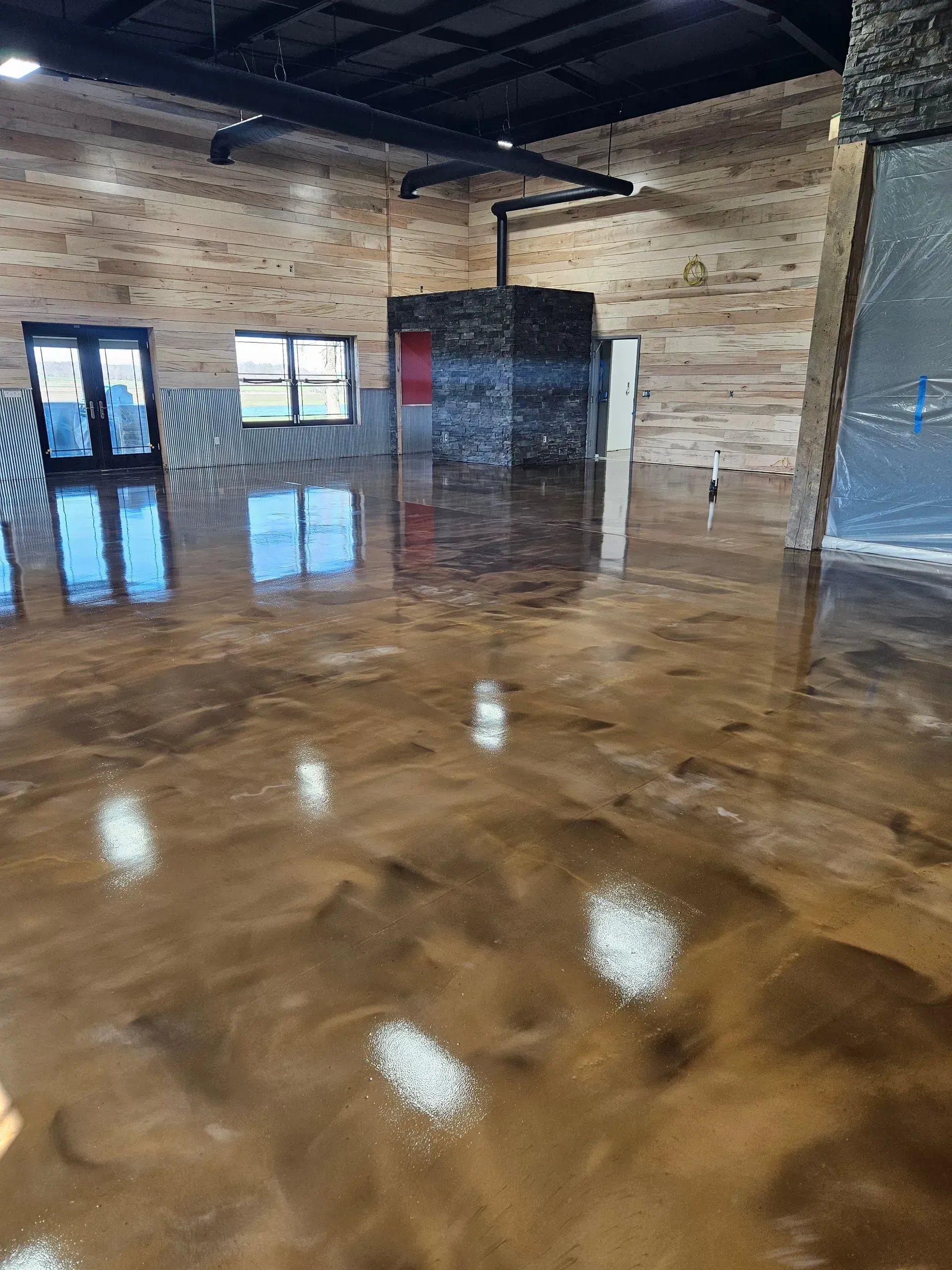 A large room with a shiny metallic floor and wooden walls.