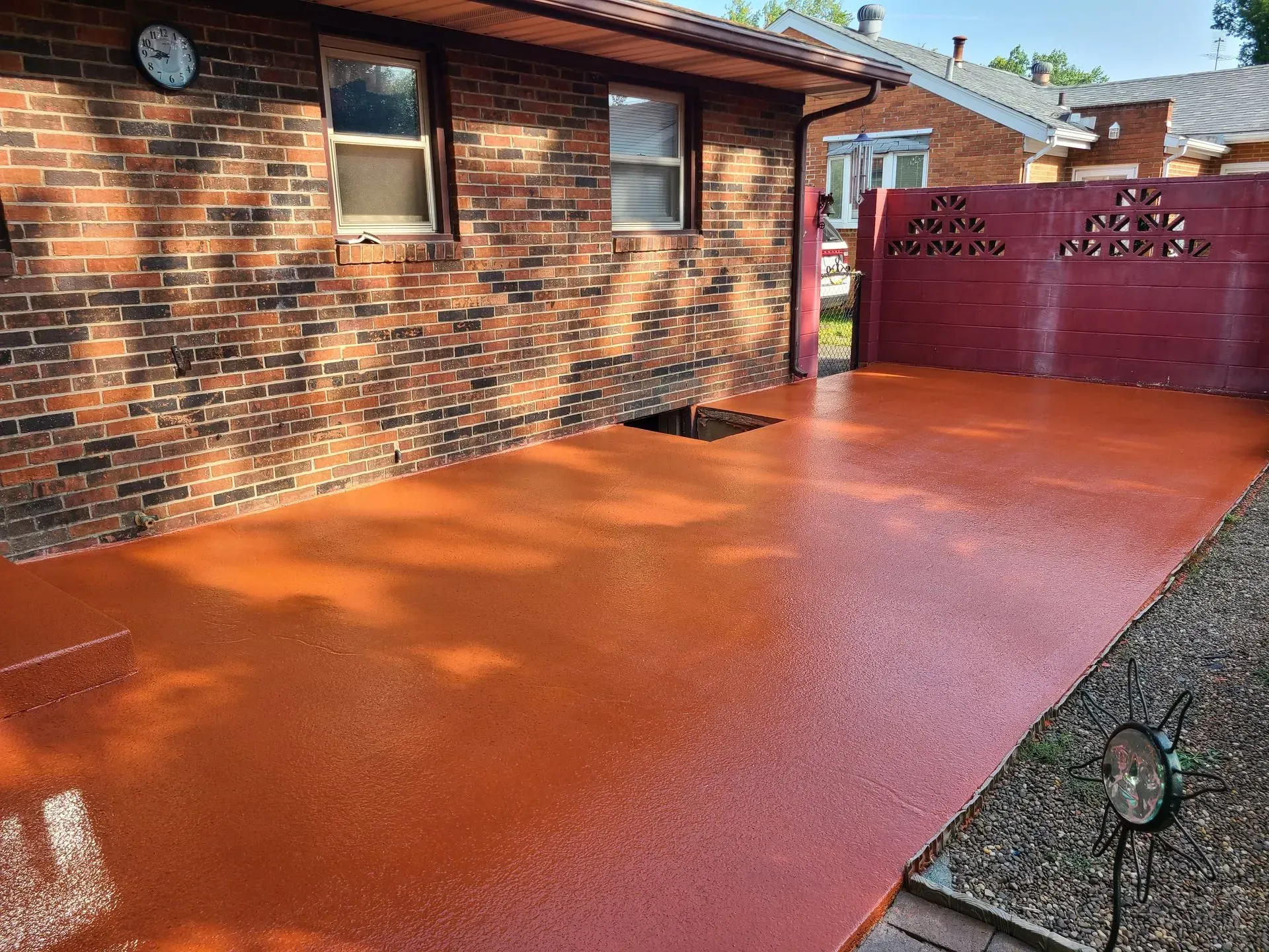A brick house with a red driveway in front of it.