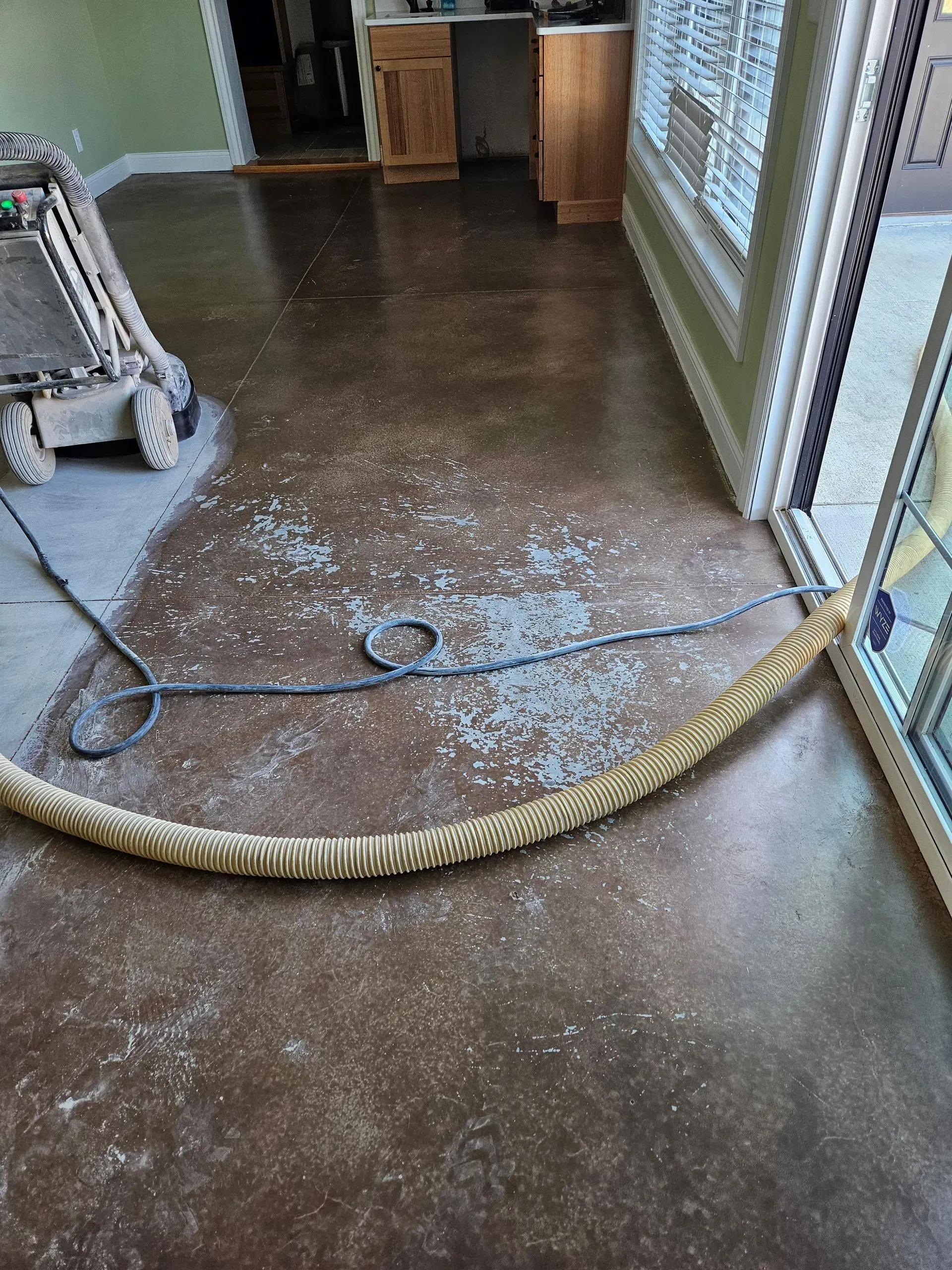 A vacuum cleaner is sitting on the floor of a room next to a window.