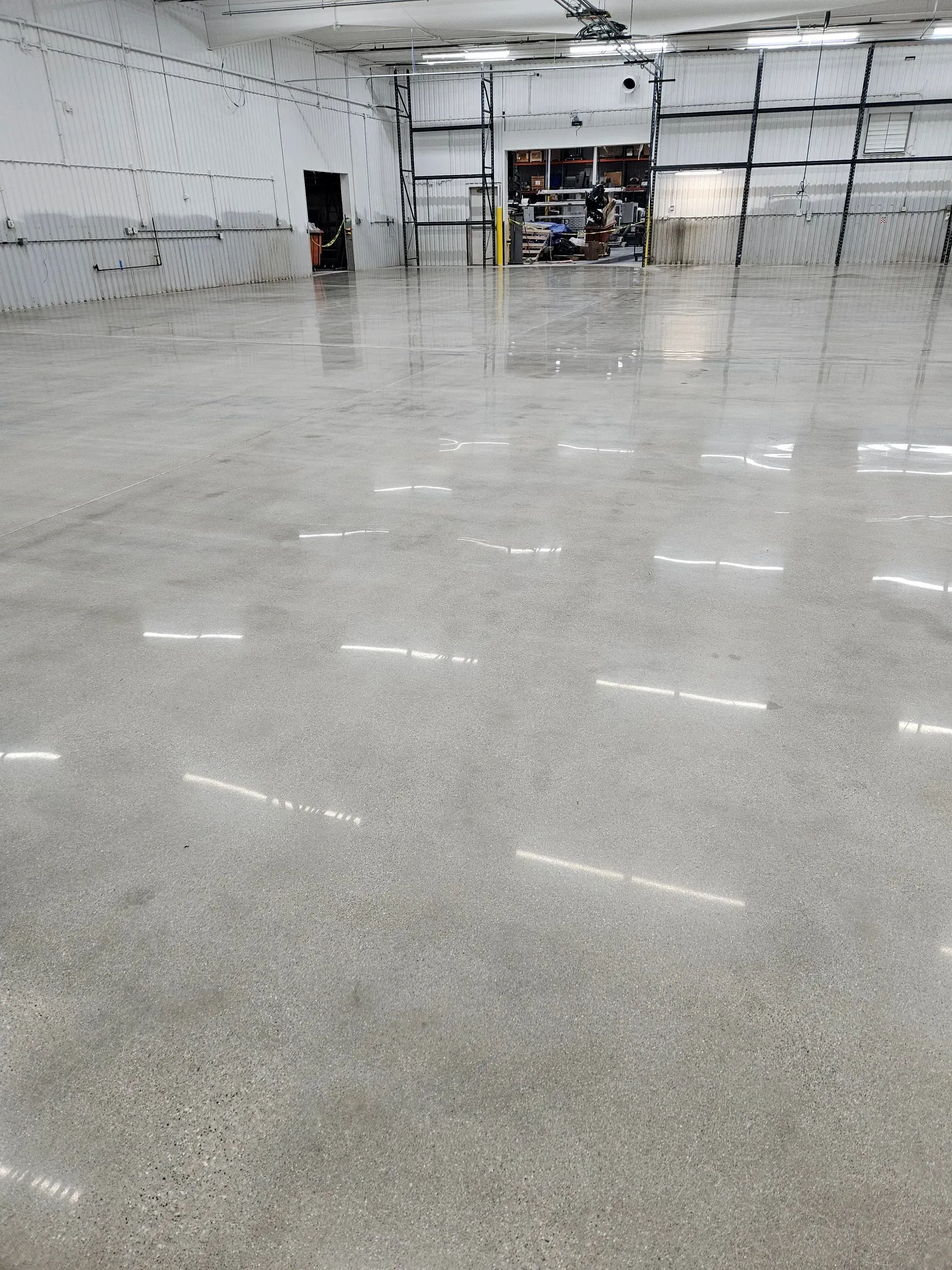 A large warehouse with a shiny concrete floor
