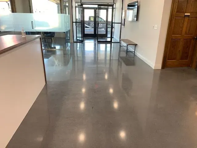 A lobby with a shiny concrete floor and a bench