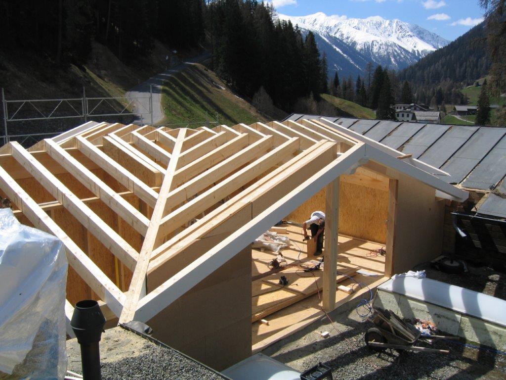 Mit Bergen im Hintergrund wird eine Holzkonstruktion gebaut