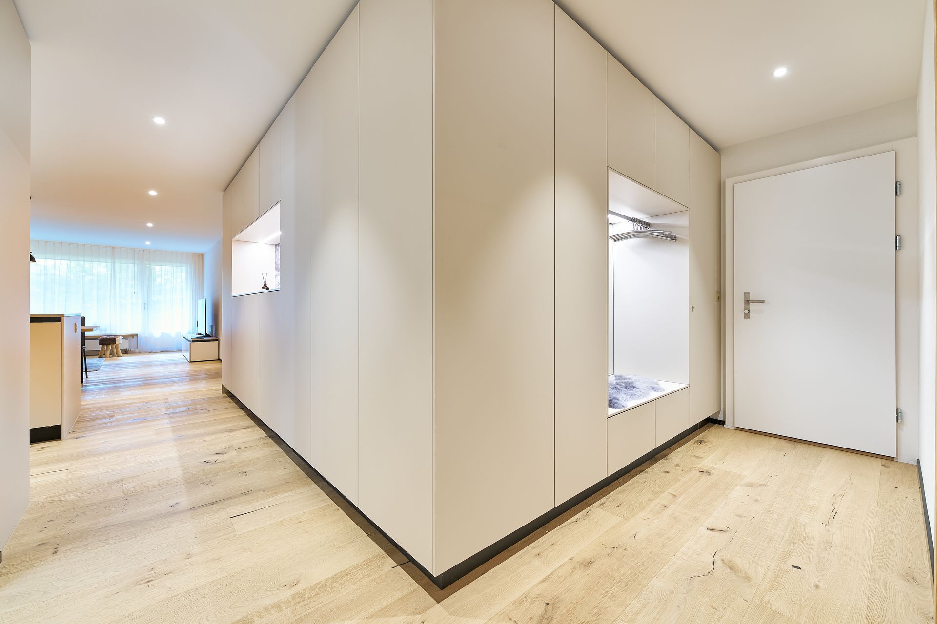 Ein Flur mit weißen Wänden und einer weißen Tür