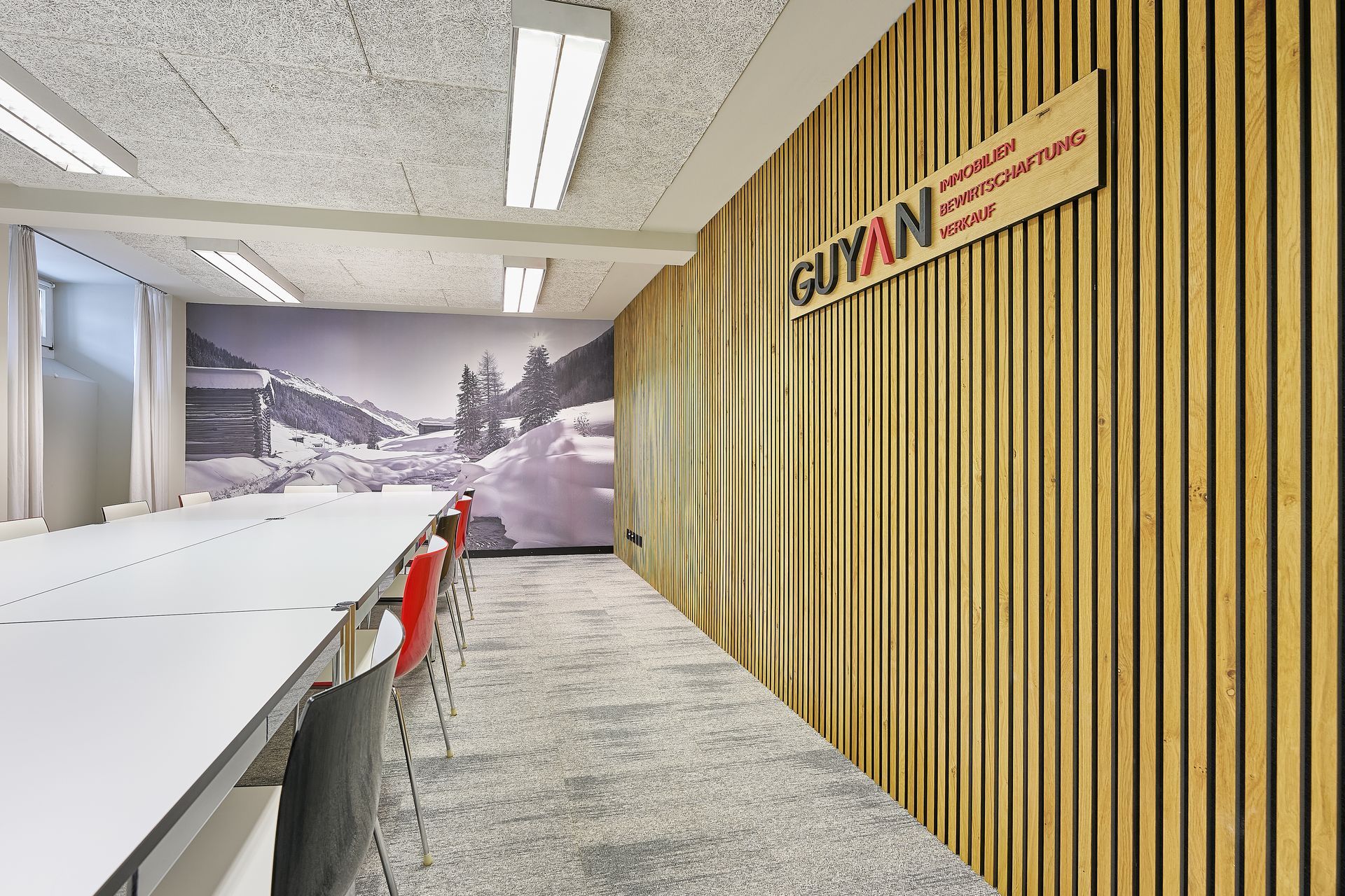 Ein langer Flur mit einer Holzwand und einem Schild mit der Aufschrift „Guyan“ darauf.